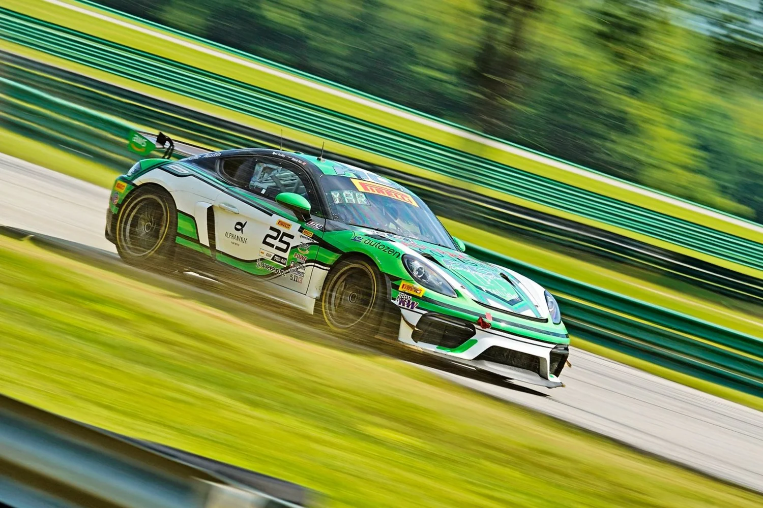 Green and white Porsche number 25 photographed with motion blur on track