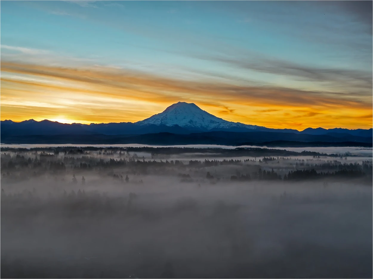 Mount Rainier above sunrise-lit fog banks