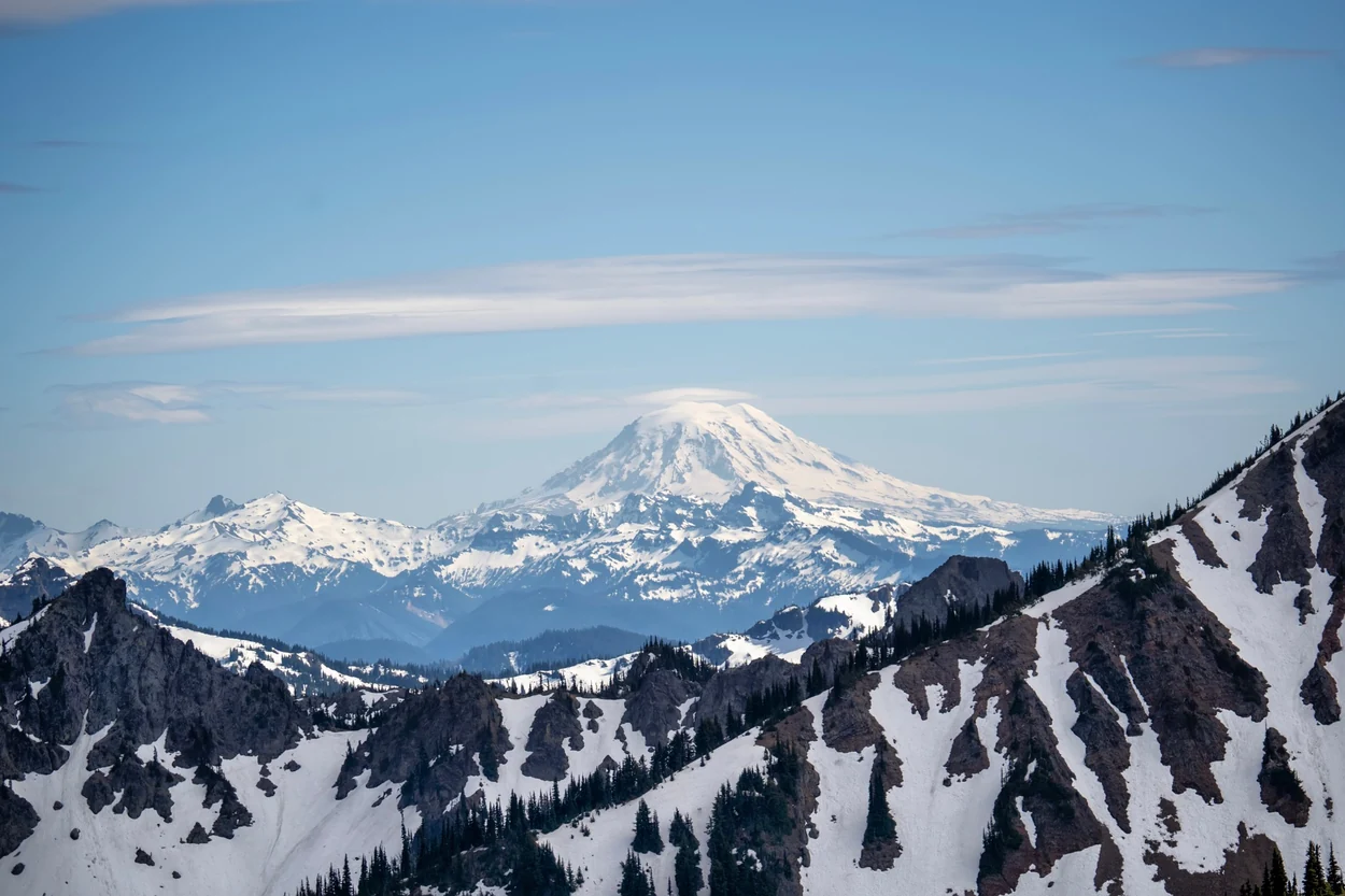 Mount Rainier rising beyond snow-lined mountain ridges